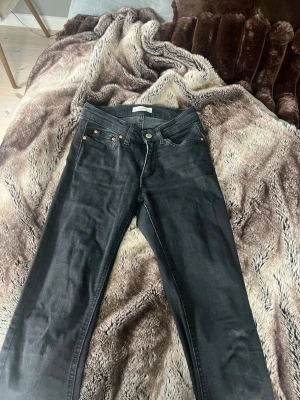 Svarta bootcut jeans - Snygga svarta jeans med klassisk femficksdesign och bootcut. Jeansen har silverfärgade nitar och knapp, samt bälteshällor i midjan. Perfekta för en stilren och avslappnad look. Från gina storlek 32