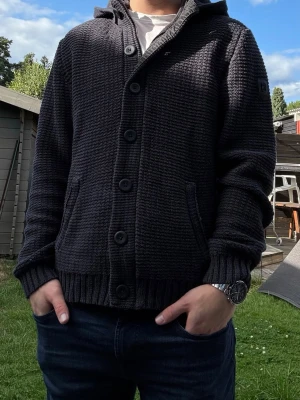 Unik cardigan / kofta - Riktigt snygg unik cardigan / kofta med luva. Den har både drakedja och knappar och är avtagbar. Fungerar som både ytterplagg och kofta. Storlek XL men passar M. Fint skick.