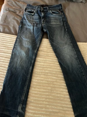 Mörkblå Replay jeans slim fit - Säljer ett par mörkblå jeans med skin fit. Jeansen har klassisk femficksdesign, kontrastsömmar och en läderpatch bak i midjan. Materialet är denim i bomull och passformen är avslappnad men ändå stilren. Jeansmoddeln heter thad, passar dem som är runt 150-160