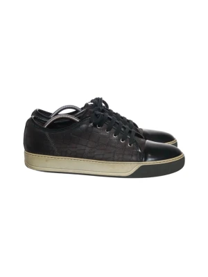 Lanvin Skor - Snygga svarta sneakers med låg profil och coolt mönstrad lädersida. Skorna har svarta snören, svart tåparti och en kontrasterande beige sula. Perfekta för dig som vill ha en stilren men unik look.