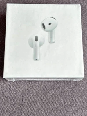 AirPods 4 med brusreducering - Säljer ett par vita Apple AirPods 4 med aktiv brusreducering. Trådlösa hörlurar i stilren design, levereras i originalförpackning. Passar perfekt till musik, samtal och gaming. Kompatibla med USB-C-laddare.