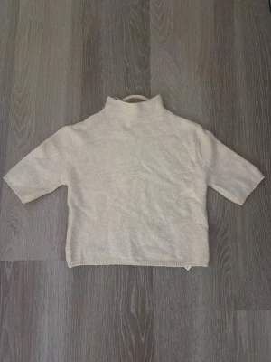 Beige stickad tröja  - Aldrig använd Beige stickad tröja från Gina Tricot med hög krage och halvlånga ärmar. Tröjan har en enkel, rak passform och är tillverkad i mjukt material som passar perfekt till lager på lager. Stilren och lätt att matcha med olika outfits. 💗 