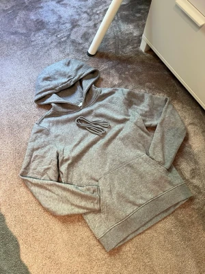 Grå Hoodie - UTFÖRSÄLJNING‼️ * Storlek: S/Xs * Skick: Mycket bra skick * Färg: Grå * Mått: Finns i sista bilderna. * (Snörren tillkommer)