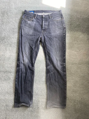 Acne studios jeans  - Ett par riktigt snygga gråa jeans från acne studios i storlek 30/34, med riktigt snygga slitningar och fades. Skick mycket bra. Han på bilden är 179. Har du några frågor? Fråga pp