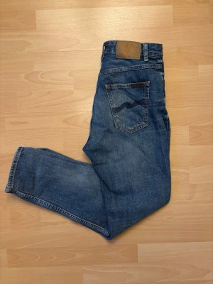 Nudie Jeans - Slitningar  - Snygga blå Nudie Jeans med fina och trendiga slitningar. Klassisk denimtvätt och snygg passform. I bra begagnat skick. 📏 Storlek: W29 L28 👖 Färg: Blå 📦 Skickas snabbt