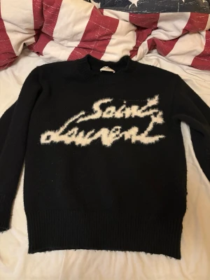 Stickad Saint laurent  - Säljer min stickad Saint Laurent tröja för att jag gillar inte hur den sitter på mig. Knappt använd och ingen tecken på skada eller användning. Den är i storlek S men kan passa för folk som har M