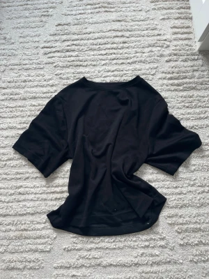 Svart basic t-shirt 157 - En svart basic t-shirt från 157 i storlek S. T-shirten har rund halsringning och korta ärmar. Tillverkad i mjukt och bekvämt material, perfekt för en clean och enkel stil.