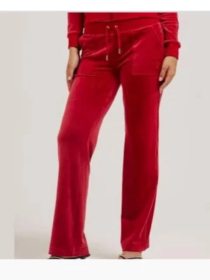 Juicy byxor - Snygga röda mjukisbyxor i mjuk velour med raka ben och dragsko i midjan. Byxorna har en ficka framtill och avslappnad passform som ger en chill vibe. Perfekta för dig som vill ha både stil och komfort.