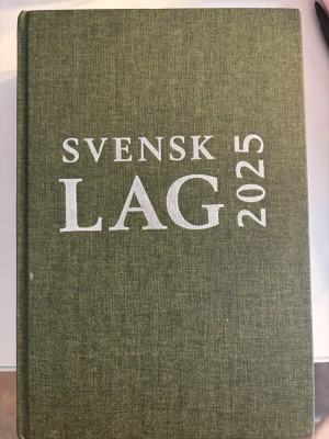 Svensk Lag 2025 kursbok - Säljer kursboken Svensk Lag 2025 med hård, grön textilklädd pärm och tydlig vit text på omslaget. Perfekt för juridikstudier och innehåller alla viktiga lagtexter. Boken är tjock och har tunna vita sidor med svart tryck.                                   ISBN: 9789177372707