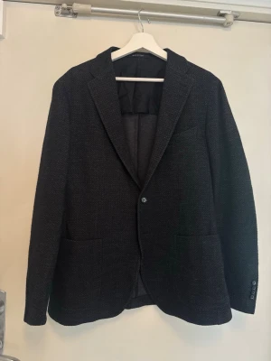 Mörkgrå Tagliatore kavaj  - Stilren mörkgrå kavaj med två framfickor och enkelknäppning. Kavajen har en klassisk passform och lyxig ullblandning som är perfekt för alla tillfällen! | Storlek: 54 (M/L) | Skick: 9/10 | Nypris: 7899kr | Meddela vid eventuella frågor! Mvh ResellGarms 