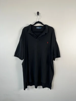 Vintage Ralph Lauren Polo Pikétröja XL Svart Classic Fit Y2K - • Storlek: XL • Färg: Svart • Passform: Classic Fit  • Krage: Klassisk pikékrage • Material: 100% bomull   Skick: Plagget är i väldigt fint skick. Eventuella anmärkningar anges alltid tydligt i beskrivningen och visas på bilderna.  Nypris: Cirka 1 500 kr.  📦 Skickas snabbt och packas omsorgsfullt. 💬 Hör gärna av dig om du har frågor eller vill se fler bilder. 🤝 Samfrakt erbjuds vid köp av flera plagg – kika gärna in mina andra annonser!