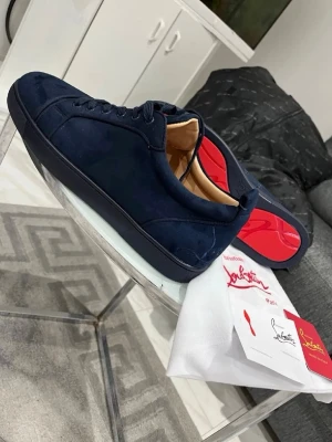 Mörkblå sneakers från Louboutin - Pris kan diskuteras vid snabba affärer❗️❗️Snygga mörkblå sneakers i mocka från Christian Louboutin med den ikoniska röda sulan. Skorna har lågt skaft, rund tå och matchande mörkblå snörning. Perfekta för dig som vill sticka ut med exklusiva detaljer och lyxig känsla.