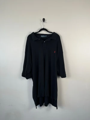 Vintage Polo Ralph Lauren Piké 2XLT Tall XXL Svart Röd Pony 100% Bomull - • Storlek: XXL  • Färg: Svart • Passform: Classic Fit  • Krage: Klassisk ribbad pikékrage • Material: 100% bomull  Skick: Plagget är i väldigt fint skick. Eventuella anmärkningar anges alltid tydligt i beskrivningen och visas på bilderna.  Nypris: Cirka 1 700 kr.  📦 Skickas snabbt och packas omsorgsfullt. 💬 Hör gärna av dig om du har frågor eller vill se fler bilder. 🤝 Samfrakt erbjuds vid köp av flera plagg – kika gärna in mina andra annonser!