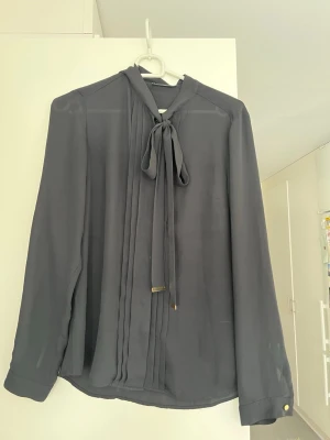 Svart blus med knytband - Svart blus i storlek 36. Den är i fint skick.