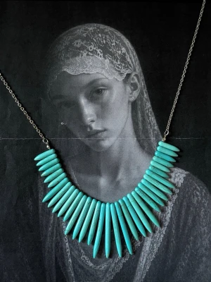 Turkost statementhalsband med pärlor - Snyggt halsband med långa, spetsiga pärlor i turkos färg. Pärlorna är trädda på en tunn metallkedja och har en cool, bohemisk vibe. 