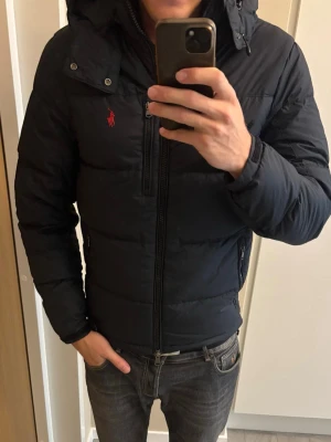 Jättefin svart Ralph lauren dun vinterjacka XS - Jättefin populär eftertraktad svart Ralph lauren dun vinterjacka av hangars kvalité och storlek XS. Otroligt plagg i utmärkt skick och väldigt varm och skön! Tveka inte vid minsta fråga eller fundering! 45 cm axelbredd och 65 cm ärmlängd