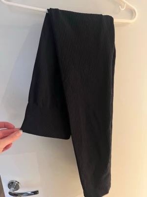 Svarta ribbade leggings - Säljer ett par bekväma svarta stretchiga leggings med hög midja struktur. Från Gina tricot, storlek S/M.