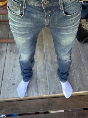 Replay anbass - Säljer ett par blå slim fit jeans med snygga slitningar och tvättade detaljer. Jeansen har klassisk femficksmodell, normalhög midja och smal passform hela vägen ner. Perfekta för en avslappnad och trendig look.