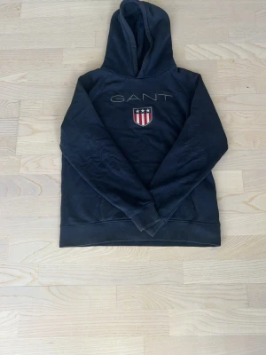 Mörkblå hoodie från GANT - Tja, säljer nu en snygg GANT tröja i bra skick. Har använts rätt så mycket. Storlek: 170cm. Hör av er om frågor och prisfunderingar m.m!😀