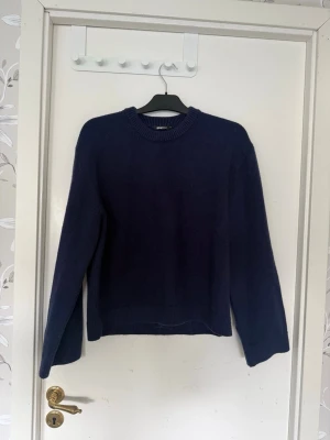 Mörkblå stickad tröja - En enkel och stilren mörkblå stickad tröja med rund halsringning och långa ärmar. Tröjan har ribbade muddar vid ärmslut och nederkant. Tröjan är från Gina tricot. Används få gånger och säljes på grund av detta!🥰