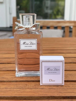 Miss Dior Rose N' Roses 100ml - Miss Dior Rose N' Roses eau de toilette 100ml. Flaskan är använd och har ca 80% kvar av parfymen. På köpet får du med en travel size parfym på 5 ml som är oanvänd med en söt liten förpackning. 