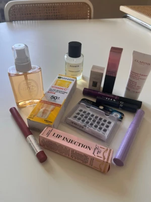 Blandat skönhetspaket med smink & hudvård - Ett paket med olika skönhetsprodukter, inklusive Läppglans från Too Faced. Scrub Clarins. Läppenna Maybeline. Fransar Depend. Parfym Essnce. Mascara Isadora och Sephora. Tinted cc cream glow Garnier. Lipgloss Lyko. Ansiktsglitter Eco. Allt är oanvänt/swatchat på ren baksida hand. Några produkter är förseglade. 