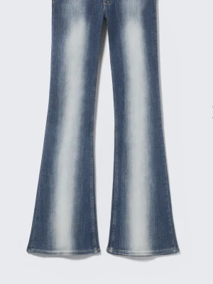Blå utsvängda jeans med slitningar - Säljer ett par blå jeans med utsvängda ben och låg midjal. Från weekday I strl 28/30, slutsålda men nypris 399. Jag är ca 168 och de sitter till över mina fötter ungefär.
