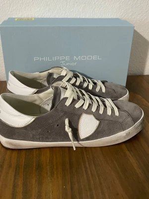 Grå Philippe Model sneakers i mocka - Philippe Model Junior sneakers - Storlek 40  Säljer ett par Philippe Model Junior i storlek 40. Använda endast cirka 4 gånger, så de är i princip i nyskick utan några större tecken på  användning.Hör av dig vid frågor eller om du vill ha fler bilder.