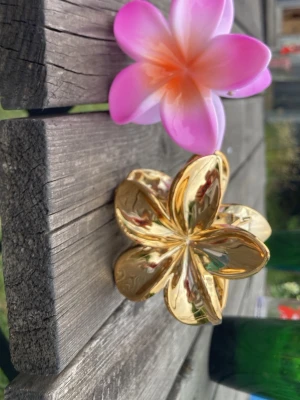  Blomhårklämma rosa och guldig  - 2 hårklämmor, en guldig och en rosa orange. den rosa orange är aldrig använt och den guldiga använt få gånger