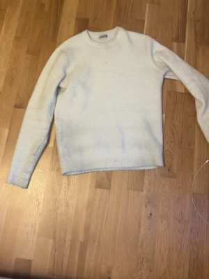 Vit stickad tröja - En vit stickad tröja ifrån Calliope. Tröjan är en blandning av polyester, acrylic och ull. En väldigt skön och snygg tröja som passar perfekt till vinter och höst. Inga defekter och i är i mycket bra skick. Pris kan diskuteras.