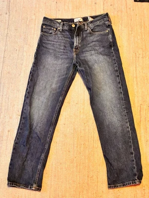 Mörkblå relaxed jeans Jack & Jones - Säljer ett par mörkblå jeans från Jack & Jones i modellen Relaxed/Chris. Jeansen har en avslappnad passform. Materialet är denim i bomull med snygg tvätt och slitningar på låren. De är använda men ack så snygga de är alltså. Perfekt för en lite laidback look eller allmänt snygga också. Hör av dig!