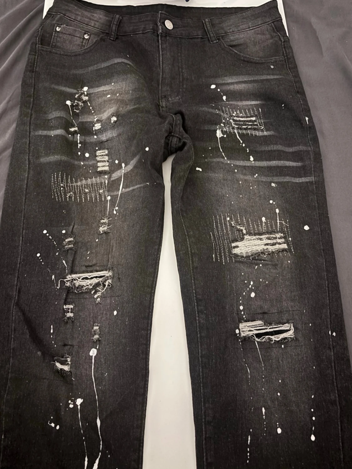 Svarta distressed jeans med färgstänk