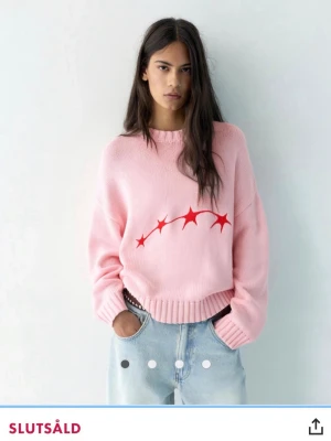 Rosa stickad tröja med rött tryck - Säljer en oversized rosa stickad tröja med rund hals och ribbade muddar. Jätte fin rosa tröja med stjärnmotiv mysig till hösten. Unik men jätte fin ALLDRIG använt därmed säljs. Skulle absolut säga att S oxå hade passat i den💕🩷🥰