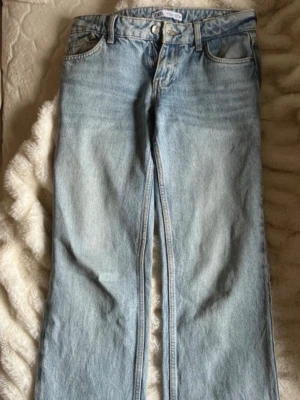 Populära ljusblå lågmidjade raka jeans från Zara - Säljer ett par ljusblå jeans med rak passform och klassisk femficksdesign. Jeansen har låg midja och är tillverkade i denim med en snygg tvättad look. Perfekta till en avslappnad stil och passar till det mesta i garderoben. De är från Zara och mycket populära, ofta slutsålda. Jätte bra skick, postar snabbt!