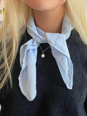 Ljusblå scarf i tunt tyg - Snygg ljusblå scarf🩵🤍 Jättecool detalj som piffar upp en outfit vid alla tillfällen! Kan bäras på många sätt, i håret, på väskan, runt halsen osv. Handgjord och lokaltillverkad av återbrukade tyger vilket gör den miljövänlig.
