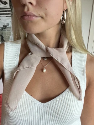 Beige scarf i tunt tyg - Beige scarf i tunt tyg🤍🤎 Jättecool detalj som piffar upp en outfit vid alla tillfällen! Kan bäras på många sätt, i håret, på väskan, runt halsen osv. Handgjord och lokaltillverkad av återbrukade tyger vilket gör den miljövänlig.