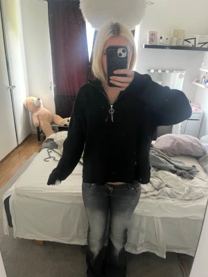 Svart ziptröja med krage - Säljer en svart långärmad ziptröja med hög krage och dragkedja med ringdetalj. Skulle säga att de är storlek S men det passar nån i M också.