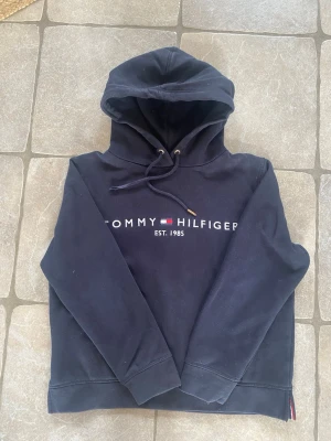 Mörkblå  Tommy Hilfiger hoodie  - Snygg mörkblå hoodie från Tommy Hilfiger i storlek XS. Jag köpte den för nypris 980 kr men säljer den nu för 160 och priset kan absolut diskuteras💗