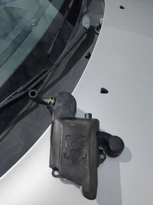 Svart plastbehållare till bilmotor - En svart vevhus den kommer ifrån volvo v70 årsmodell 2001 troligen en del till bilens motorsystem. Formen är oregelbunden och den har fästhål för montering. Passar för dig som behöver reservdel till bilen.