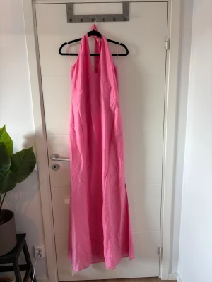 Rosa långklänning med halterneck - ADOORE Andrea Halter Dress – Hot Pink – stl 48  Helt ny med lappar kvar. Elegant maxiklänning med halterneck, öppen rygg med knytning och slits baktill. Aldrig använd. Modellen finns inte längre i sortimentet och är därför svår att få tag på. Storlek 48.                   Har bundle-rabatt så kolla gärna in min sida. Buda gärna🧡
