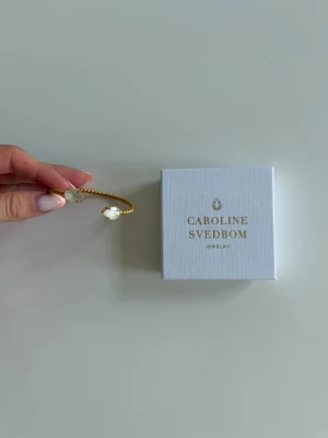 Guldarmband Caroline Svedbom - Snyggt guldarmband från Caroline Svedbom i färgen ”Electric white” super fint och stilrent. Det kommer tyvärr inte längre till användning och är i super fint skick!💕😊