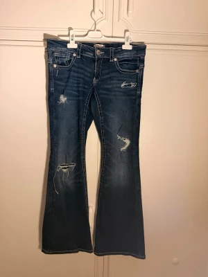 Lågmidjade mörkblåa jeans  - Jätte snygga Lågmidjade mörkblåa jeans från Gina Tricot i storlek 170. De har använts många gånger men sedan inte kommit till användning. Personer som gillar väldigt Lågmidjade jeans hade älskat dessa! De har några slitningar och sedan en femficksdesign på baksidans fickor.