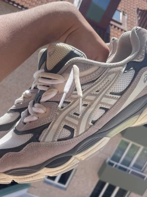 Sneakers - Säljer ett par fräscha sneakers i vitt och grått med mesh och mockadetaljer. Skorna har en chunky sula och klassisk snörning. Perfekta för dig som gillar sportig och trendig stil.