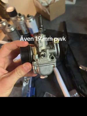 Trimrör o förgasare  - Säljer en 19 mm PWK förgasare från YSN i metall, perfekt för dig som vill trimma mopeden eller scootern. Kompakt design med flera anslutningar och justeringsmöjligheter. Passar till många olika modeller och ger bättre prestanda.