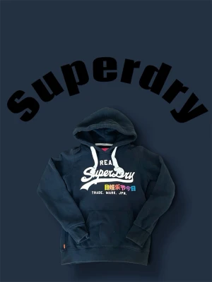 Superdry hoodie - • Svart hoodie från superdry.                                     • Storlek XS.                                                                     • Mycket bra skick.                                                       • Mått är: bröstbredd (32cm) längd (53cm)           • Skriv vid frågor, pris kan diskuteras👌🤝