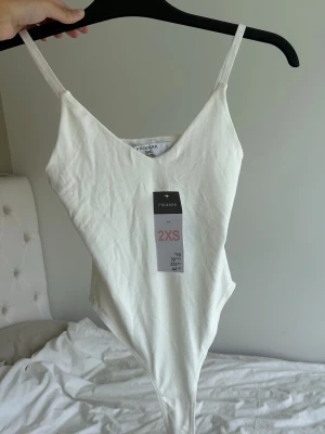 Vit body - Säljer denna oanvända vita body!🥰 storlek xxs men passar även xs. Har dubbelt tyg.
