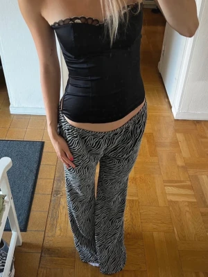 Zebramönstrade mjukisbyxor - Säljer ett par snygga mjukisbyxor med zebramönster i svart och vitt. Byxorna har en lös och bekväm passform med raka ben och resår i midjan. Perfekta för en chill och trendig look.
