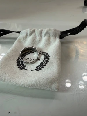 Silverfärgad ring ifrån Olympia  - Säljer en snygg silverfärgad ring som är rostfri . Ringen är justerbar 