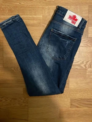 Blå slitna jeans från Dsquared2 - Säljer ett par blå jeans från Dsquared2 med slitningar. använd ett par gånger men inget fel på dem. säljer för dom inte längre är mitt stil