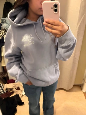 Oversized Lila hoodie med citattryck - Säljer en oversized lila hoodie med huva och magficka. På bröstet finns ett vitt tryck med texten 'Do Good & Be Nice; The Wave Of The Future'. Hoodien har ribbade muddar och dragsko i huvan. Perfekt för en chill och avslappnad stil.